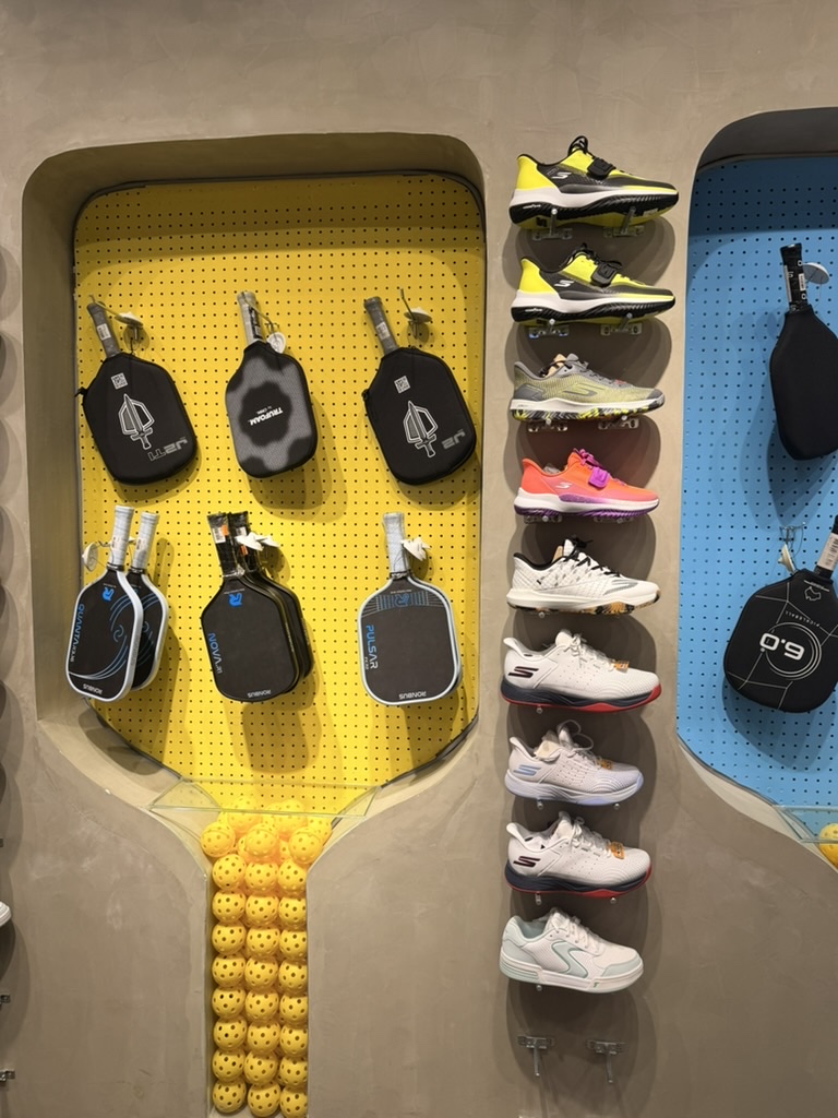 Wall of paddles and gear — the pickleball app market mirrors the gear market: too many options, most solve a different problem