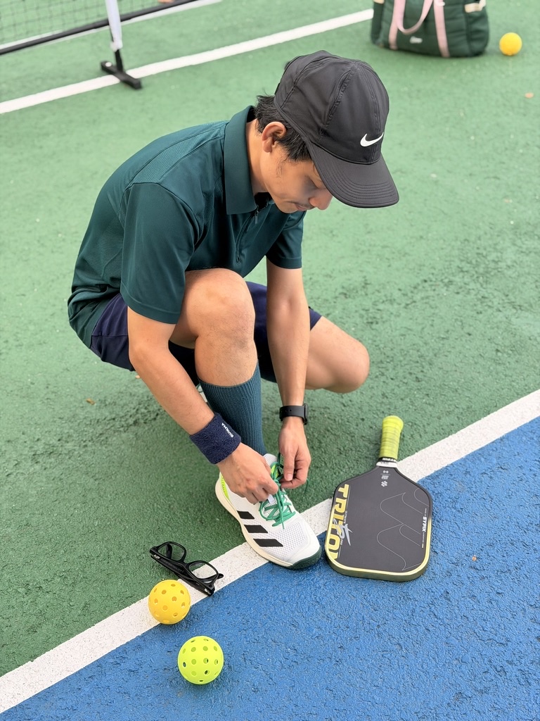 A player lacing up at the court — the small rituals of a well-run open-play night